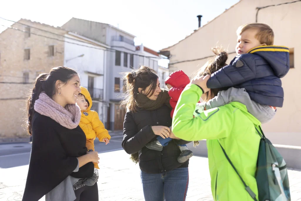 Persones amb infants en un carrer, fotografia de l’arxiu Nova Ruralitat